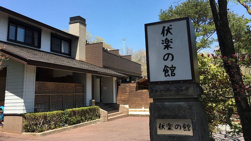 福楽の館 外観 栃木県那須湯本にある、愛犬と泊まれる宿「伏楽の館 那須湯本店」の玄関と大きな看板。青空の下、周囲の緑に囲まれた趣のある建物が、愛犬との特別な旅の始まりを告げます。