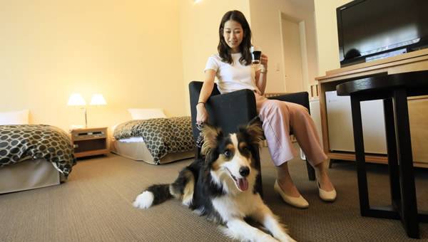 ゆとりろ蓼科ホテルwith DOGSの客室で愛犬とくつろぐ宿泊客