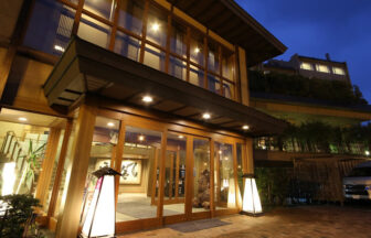 灯籠の明かりが優しく迎える旅館の夜の玄関口。和の趣を大切にした木造建築とあたたかな光が、到着した瞬間から特別な滞在を演出。｜犬と泊まれる北海道の宿｜源泉至近の温泉が自慢｜ゆとりろ洞爺湖