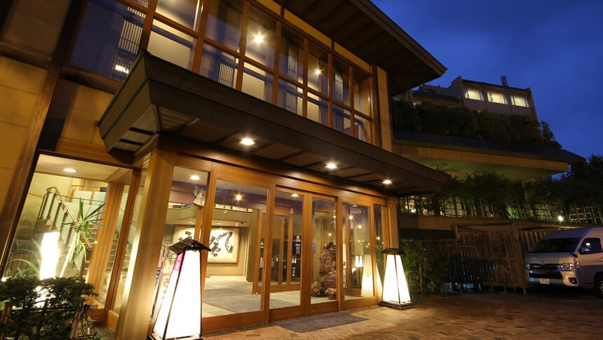 灯籠の明かりが優しく迎える旅館の夜の玄関口。和の趣を大切にした木造建築とあたたかな光が、到着した瞬間から特別な滞在を演出。｜犬と泊まれる北海道の宿｜源泉至近の温泉が自慢｜ゆとりろ洞爺湖