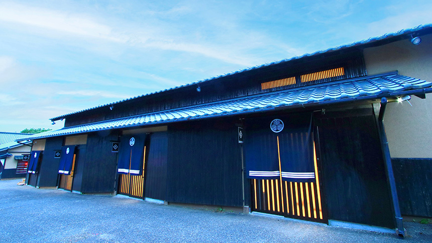 伝統的な瓦屋根と格子戸が美しい和風旅館の外観。夕暮れ時に灯る明かりが、宿泊客をあたたかく迎える落ち着いた佇まい。｜徳川の奥座敷 久能宿