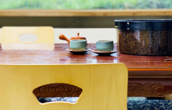 茨城県水戸市「ホテル亀屋」の和室に用意されたお茶セット。木目調の座卓、急須、茶器、茶びつのある風景