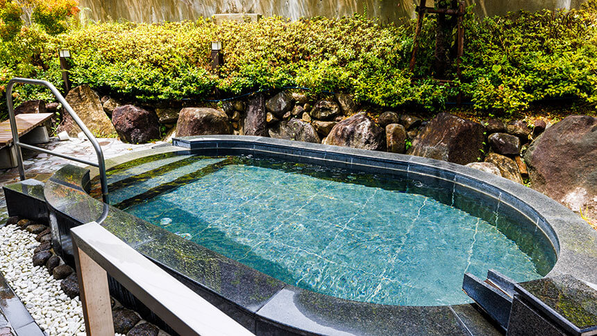 緑豊かな庭園に囲まれた、石造りの落ち着いた露天風呂。澄んだお湯が満たされており、開放感のある入浴を楽しめる。