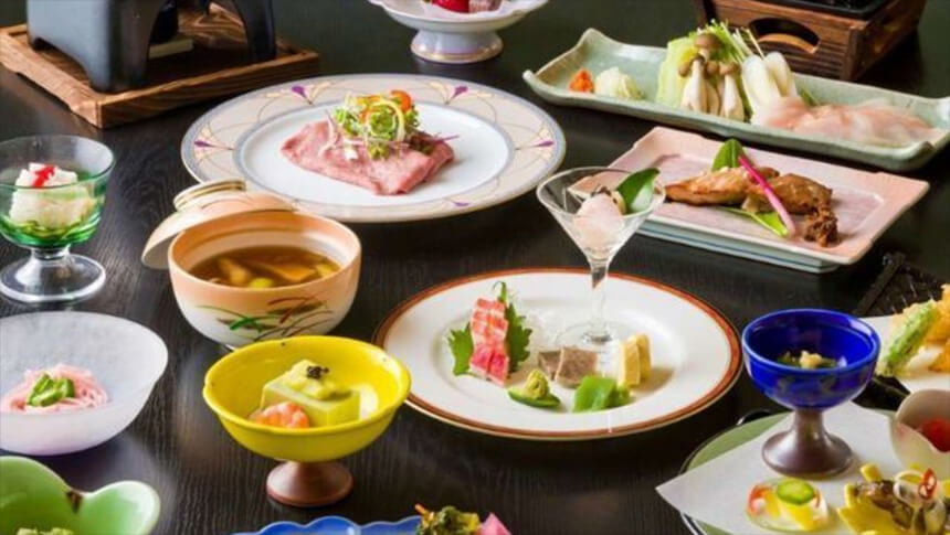 山形県・蔵王温泉にある犬と泊まれる宿「善七の湯」｜テーブルいっぱいに並んだ会席料理。ローストビーフのような肉料理、お造り、煮物、季節の小鉢などが美しい器に盛り付けられ、目でも楽しめる豪華な献立。