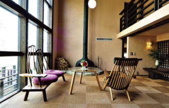 大きな窓から光が差し込むゲストハウス サンディーズのロビー。愛犬と寛げる暖炉のある空間