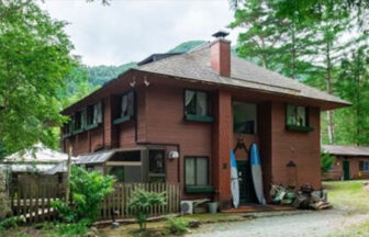 山梨県・河口湖の犬と泊まれる宿「ドッグランドサムデイ」｜森の中にひっそりと建つ、木の温もりが感じられるアットホームな宿の外観。生い茂る木々と静かな空気が漂う建物の様子。