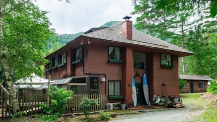 山梨県・河口湖の犬と泊まれる宿「ドッグランドサムデイ」｜森の中にひっそりと建つ、木の温もりが感じられるアットホームな宿の外観。生い茂る木々と静かな空気が漂う建物の様子。