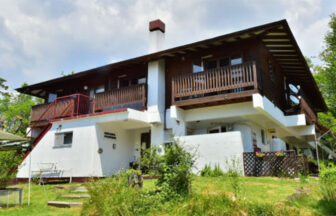 長野県・八ヶ岳中央高原にある犬と泊まれる宿「のはらペンション」の和モダンな外観。1階は白壁、2階は木の温もりを感じさせるデザインで、青空と緑豊かな自然に囲まれた佇まい