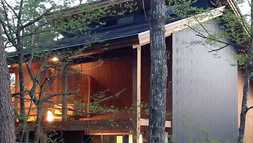 岐阜県郡上市、オートキャンプ場N.A.O.わんこパラダイスの森の中に佇む木造コテージの夜景外観