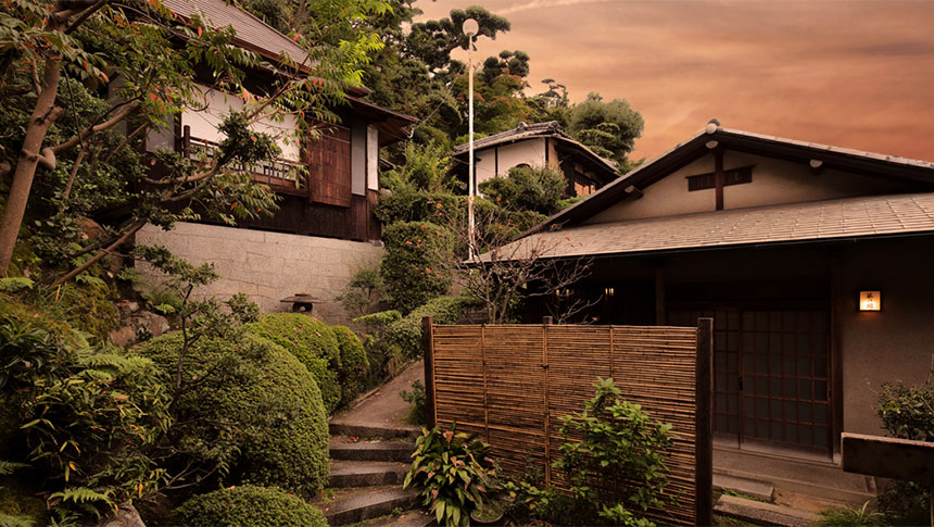 岡山県倉敷市にある犬と泊まれる宿「庭園旅館 備後屋」の外観。夕暮れ時の情緒あふれる数寄屋造りの離れと、手入れの行き届いた日本庭園、石畳の階段が続く風情ある景色｜犬と泊まれる岡山県の宿｜ペット宿ドットコム