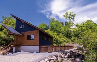 ひるがの高原の貸別荘「モリソラの家」の外観。青空の下に建つドッグラン付きのモダンな木造コテージ。