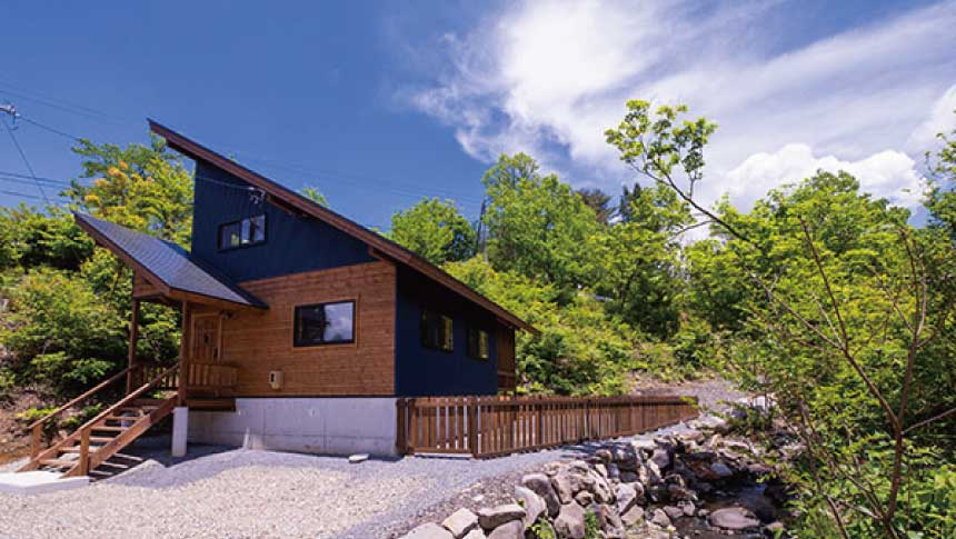 ひるがの高原の貸別荘「モリソラの家」の外観。青空の下に建つドッグラン付きのモダンな木造コテージ。