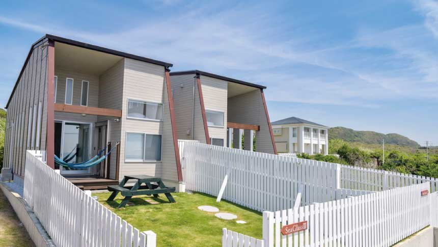 千葉県南房総市にあるペット同伴専用の貸別荘「シーグラス白浜」の外観写真。白い柵で囲まれた広い芝生の専用ドッグランが特徴。