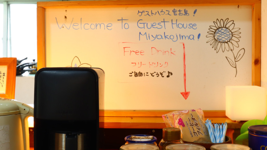 ゲストハウス宮古島の館内にあるフリードリンクコーナー。コーヒーメーカーや電気ケトル、ウェルカムボード