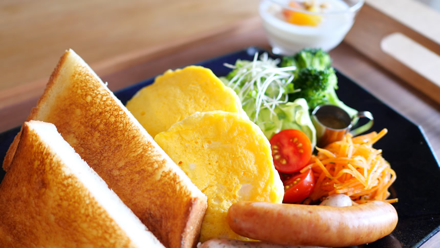 ペンションK-yardのトーストや卵料理、ソーセージを盛り付けた朝食