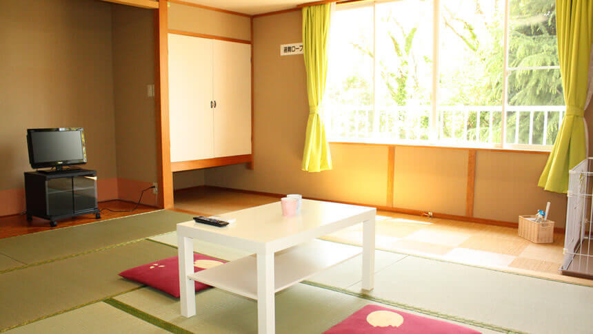 静岡県・伊豆高原にある愛犬と泊まれる宿「にこまめち」の清潔感ある客室と犬用ケージ