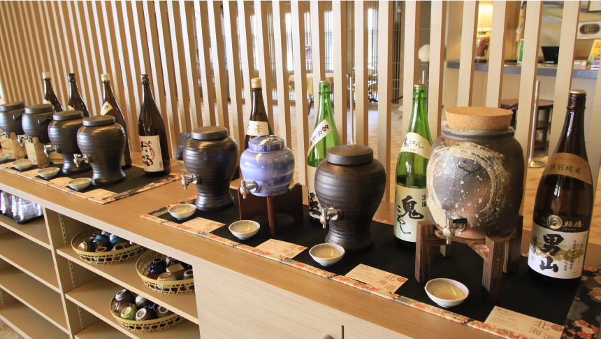 地酒が並ぶ試飲コーナー。陶器のサーバーから注がれる銘酒を楽しみながら、旅館ならではの日本文化を味わえる。｜犬と泊まれる北海道の宿｜源泉至近の温泉が自慢｜ゆとりろ洞爺湖
