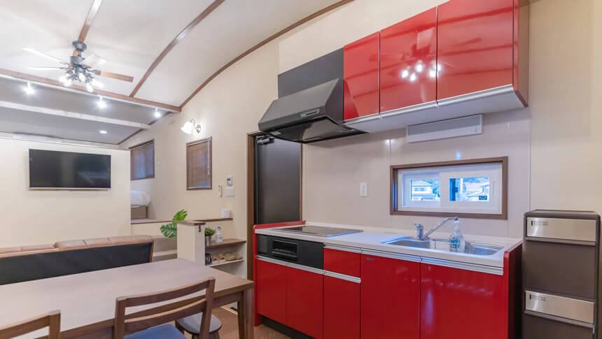 Solana鴨川の室内キッチンとリビング。赤いキッチンが映える愛犬同伴可能な宿