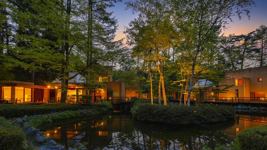 ライトアップされたフォレストヴィレッジの池とコテージの夜景