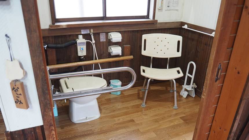 手すりや介助用椅子を備えたペンシオーネ美し松のバリアフリートイレ