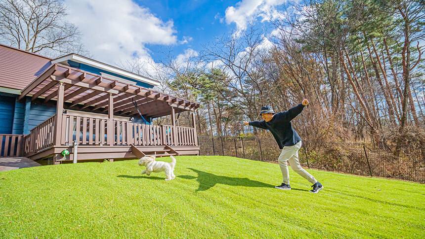 山梨県・八ヶ岳にある愛犬と泊まれる貸別荘ゆがふ「八ヶ岳」｜フェンス付きの広いドッグランで愛犬と全力で遊ぶ様子。山梨・八ヶ岳の一棟貸しの宿