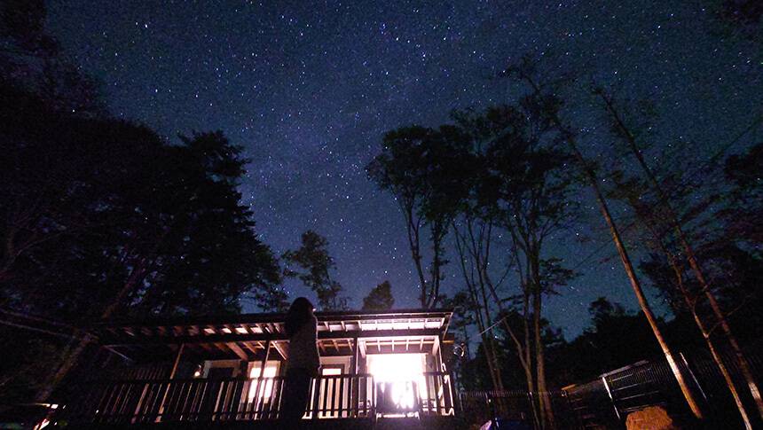 山梨県・八ヶ岳にある愛犬と泊まれる貸別荘ゆがふ「八ヶ岳」｜夜空に広がる満天の星空とライトアップされたログハウス。ペットと泊まれる貸別荘ゆがふ「八ヶ岳」での幻想的な夜