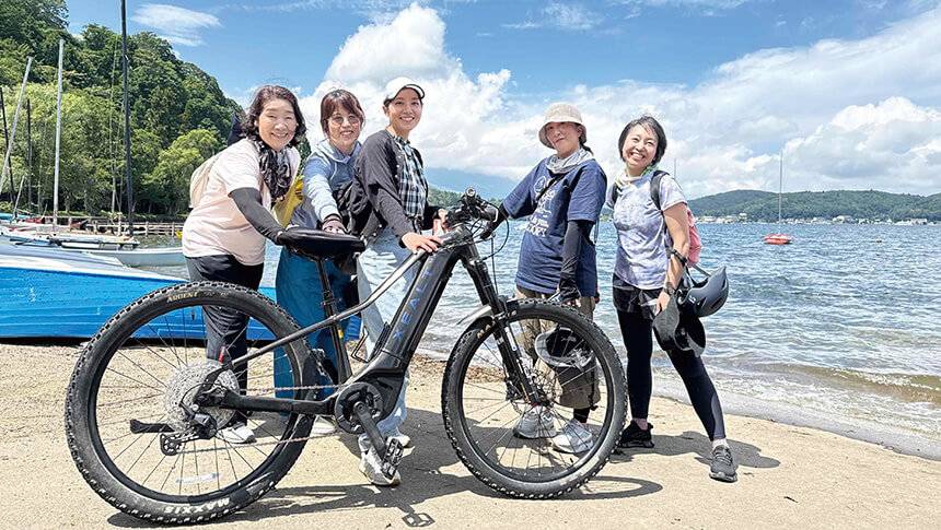 長野県黒姫高原ラボランドくろひめ周辺で楽しめるアクティビティ。湖畔でサイクリングを楽しむグループの写真