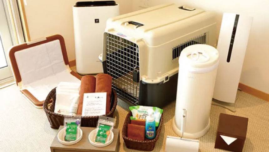 山梨県・山中湖の犬と泊まれる宿「レジーナリゾート山中湖」｜客室に用意された充実した愛犬用アメニティ。クレート、トイレトレー、空気清浄機、おやつ、消臭スプレー、粘着ローラーなどが整然と並ぶ。
