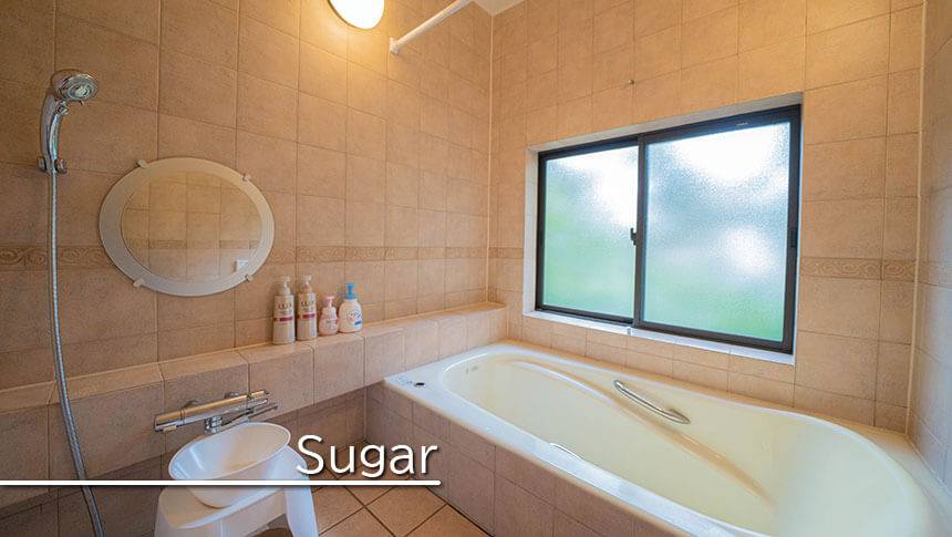 静岡県・伊豆高原の犬と泊まれる宿　ゆがふ「伊豆」｜Sugarの清潔感あふれる広々としたバスルーム。タイル張りの壁に大きな窓があり、外の緑を眺めながら入浴できる開放的なデザイン