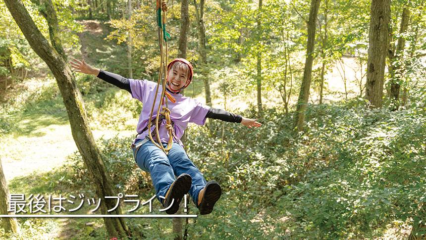 長野県黒姫高原のラボランドくろひめ。森の中でジップラインを楽しむ女性の体験シーン