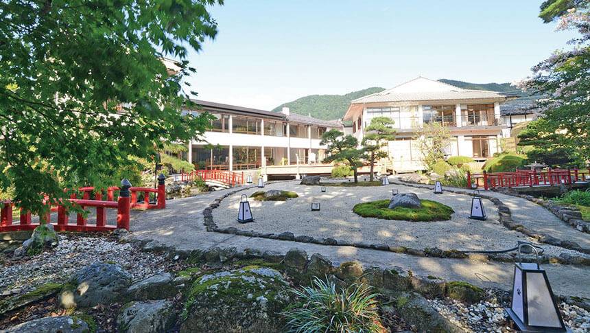 栃木県・鬼怒川にある愛犬と泊まれる温泉宿「鬼怒川絆」に広がる見事な日本庭園の全景。愛犬とのお散歩にも最適な、緑豊かな庭園と赤い太鼓橋