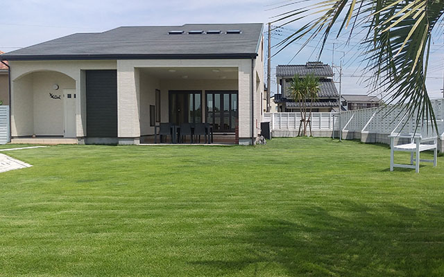 千葉県のＰＦリゾート・シエル｜手入れの行き届いた広い芝生庭がある、モダンな平屋スタイルの貸別荘。周囲は白いフェンスで囲まれている。